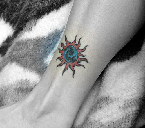 Colored Sun Tattoo On Girl Left Leg