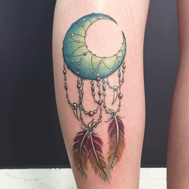 Feather With Green Moon Tattoo On Back Leg