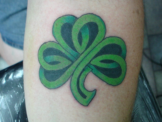 Green And Black Ink Celtic Shamrock Tattoo On Leg
