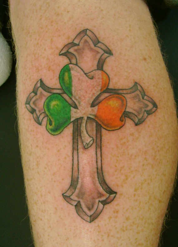 Grey Ink Cross And Shamrock Tattoos On Side Leg