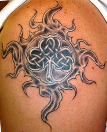 Grey Tribal Sun And Celtic Leaf Tattoo On Shoulder