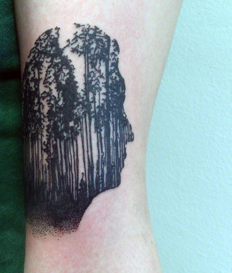 Man Face With Pine Trees Tattoo On Bicep