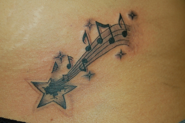 Music Notes And Shooting Stars Tattoo On Upper Back