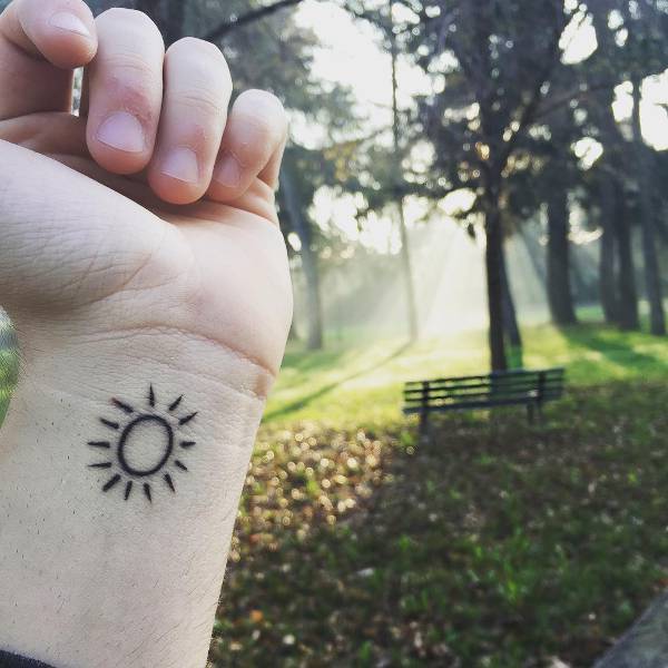 Nice Small Sun Tattoo On Left Wrist