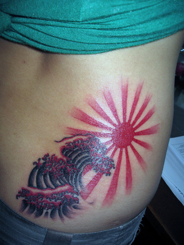 Nice Water Waves And Rising Sun Tattoo On Lower Back