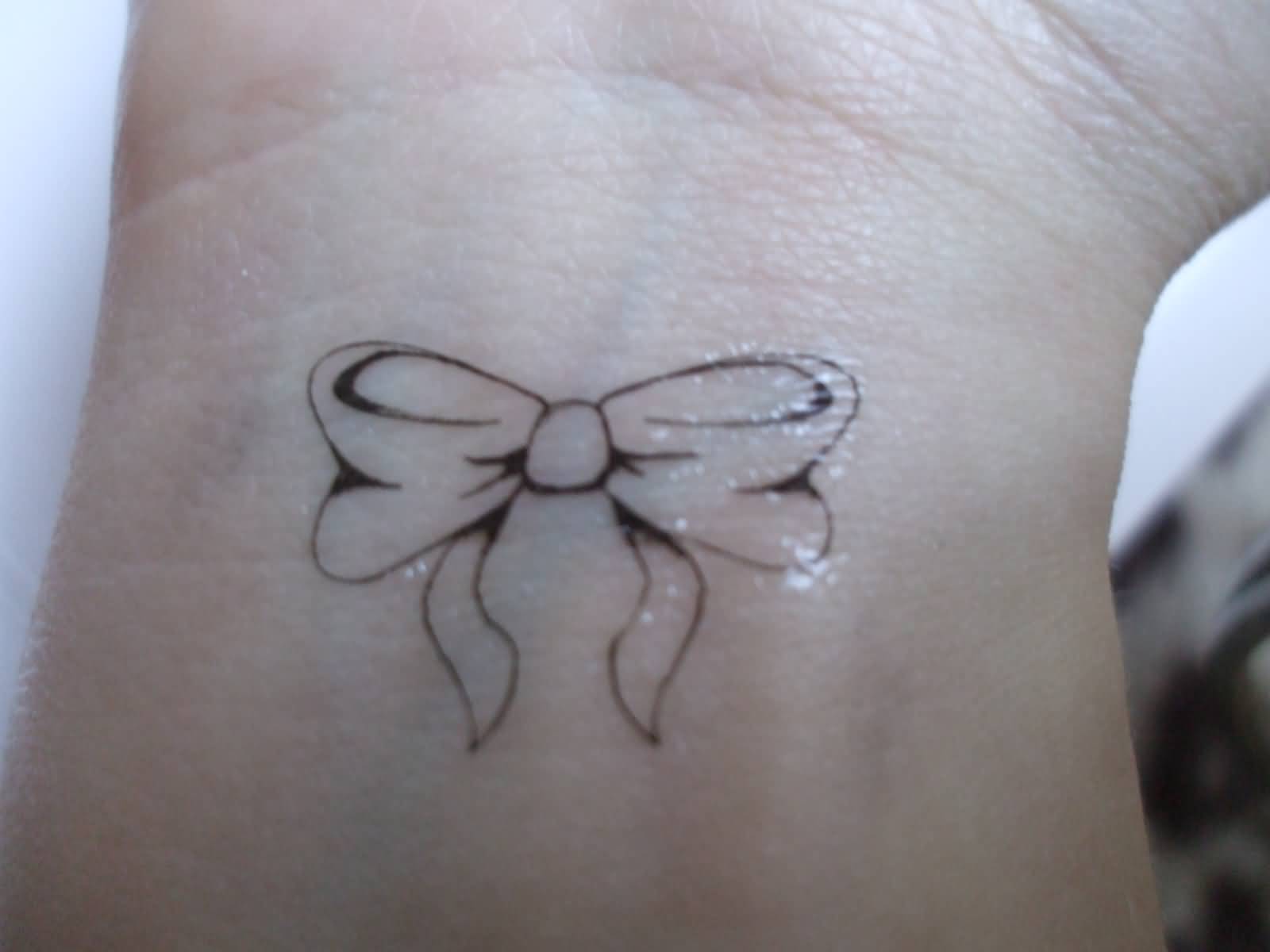 Outline Small Bow Tattoo On Wrist