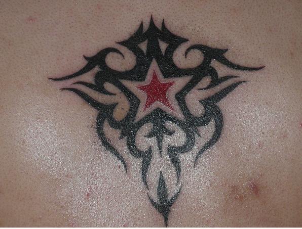 Red Star In Tribal Design Tattoo On Back