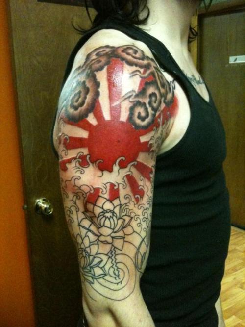 Red ink Rising Sun Tattoo On Man Right Half Sleeve