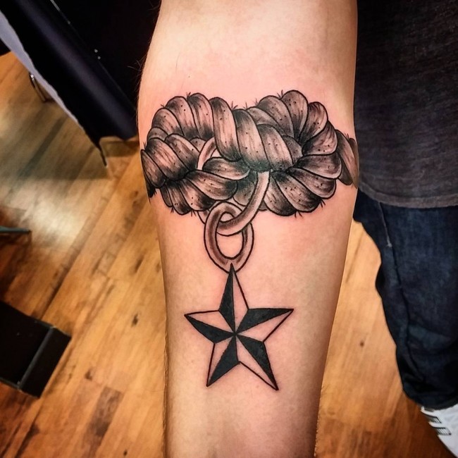 Tatuaje de un nudo de cuerda y una estrella náutica en el antebrazo derecho