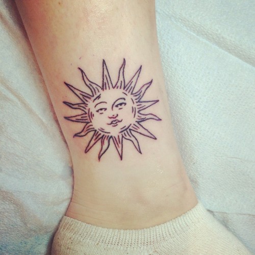 Simple Sun With Face Tattoo On Side Leg