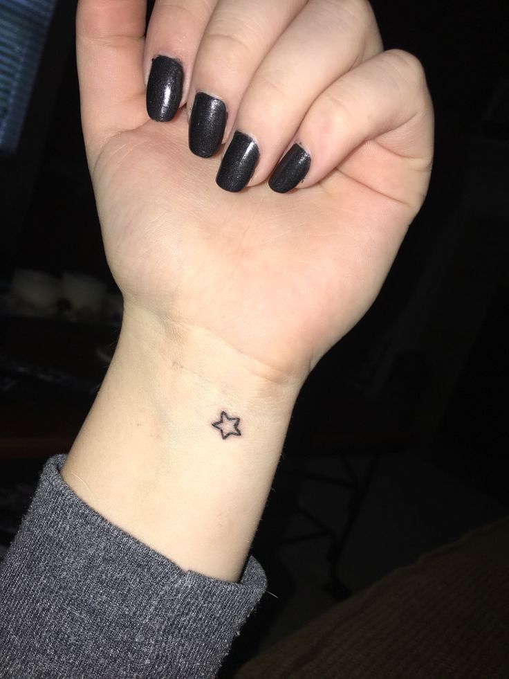 Tatuaje de una pequeña estrella en la muñeca izquierda de una chica