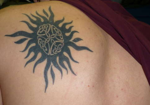 Tribal Rays And Celtic Sun Tattoo On Back Shoulder