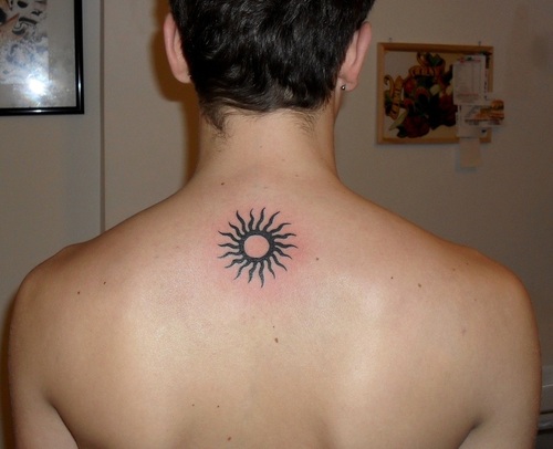Tribal Small Sun Tattoo On Man Upper Back