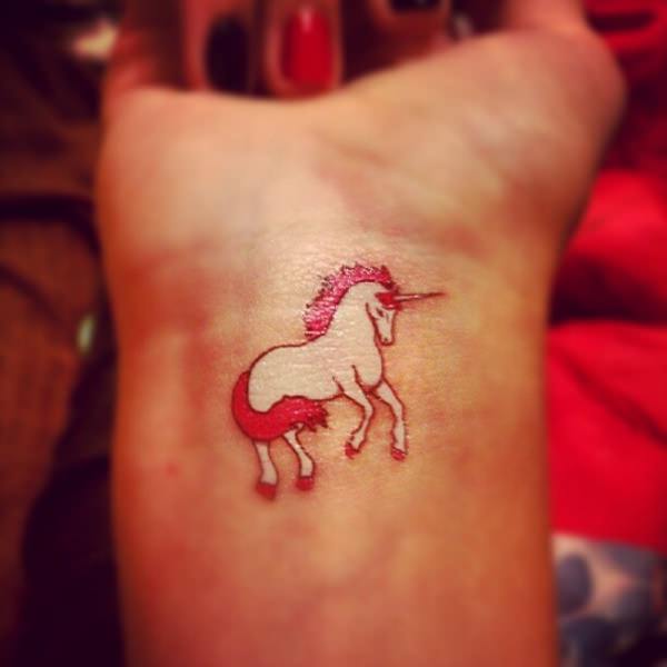 White And Red Ink Unicorn Tattoo On Right Wrist