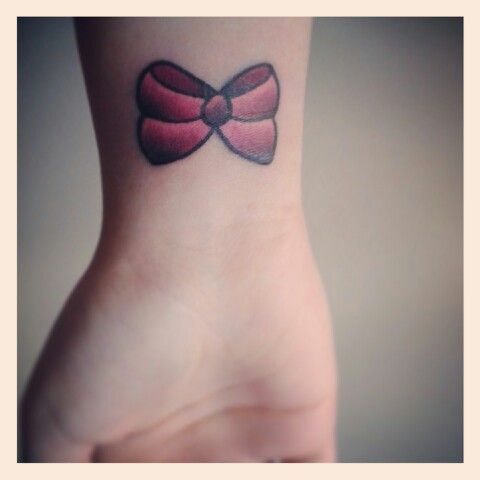 Black And Pink Ink Bow Tattoo On Girl Right Wrist