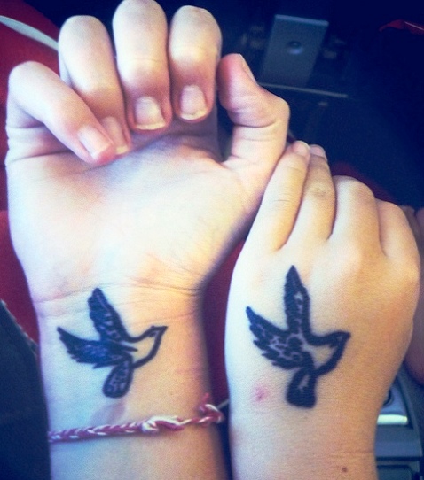 Schwarze Tinte fliegende Taube Tattoos an Handgelenken