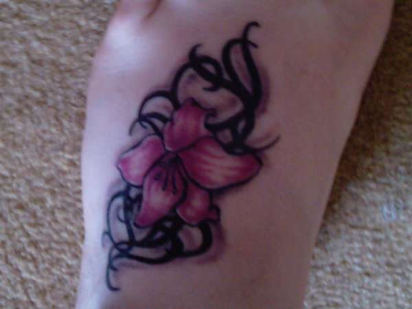 Black Tribal And Lily Flower Tattoo On Left Foot