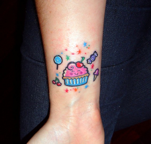 Candies And Simple Cupcake Tattoo On Forearm