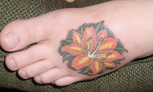 Colored Lily Flower Tattoo On Left Foot