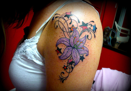 Colored Stars And Purple Lily Flower Tattoo On Shoulder