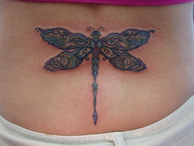 Colorful Tribal Dragonfly Tattoo On Girl Lower Back