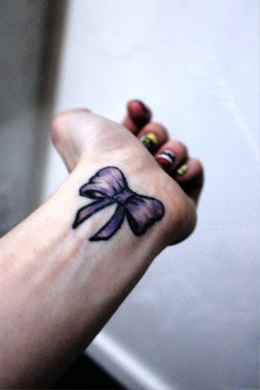 Cute Purple Bow Tattoo On Girl Left Wrist