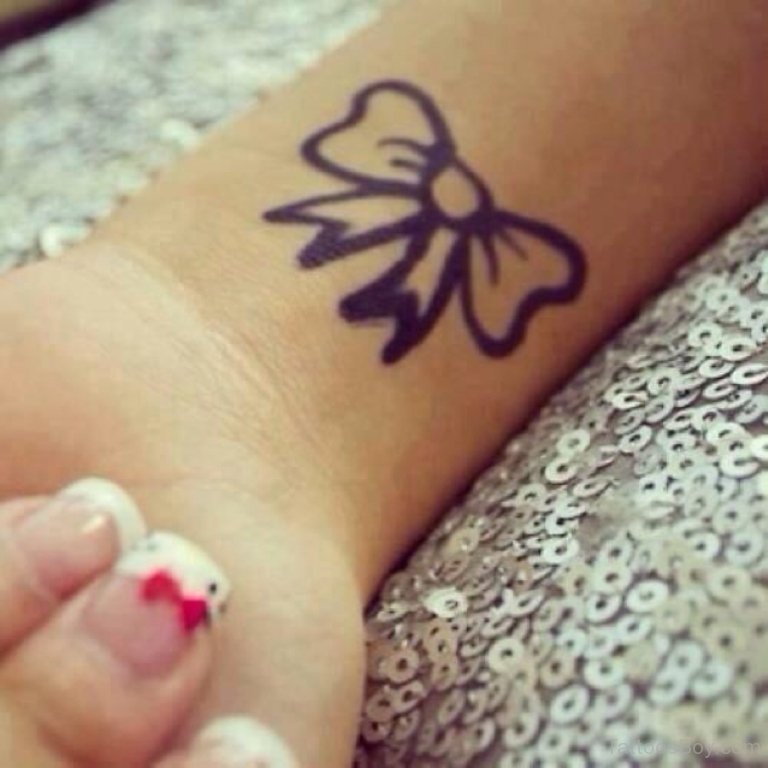Girl With Outline Bow Tattoo On Left Wrist