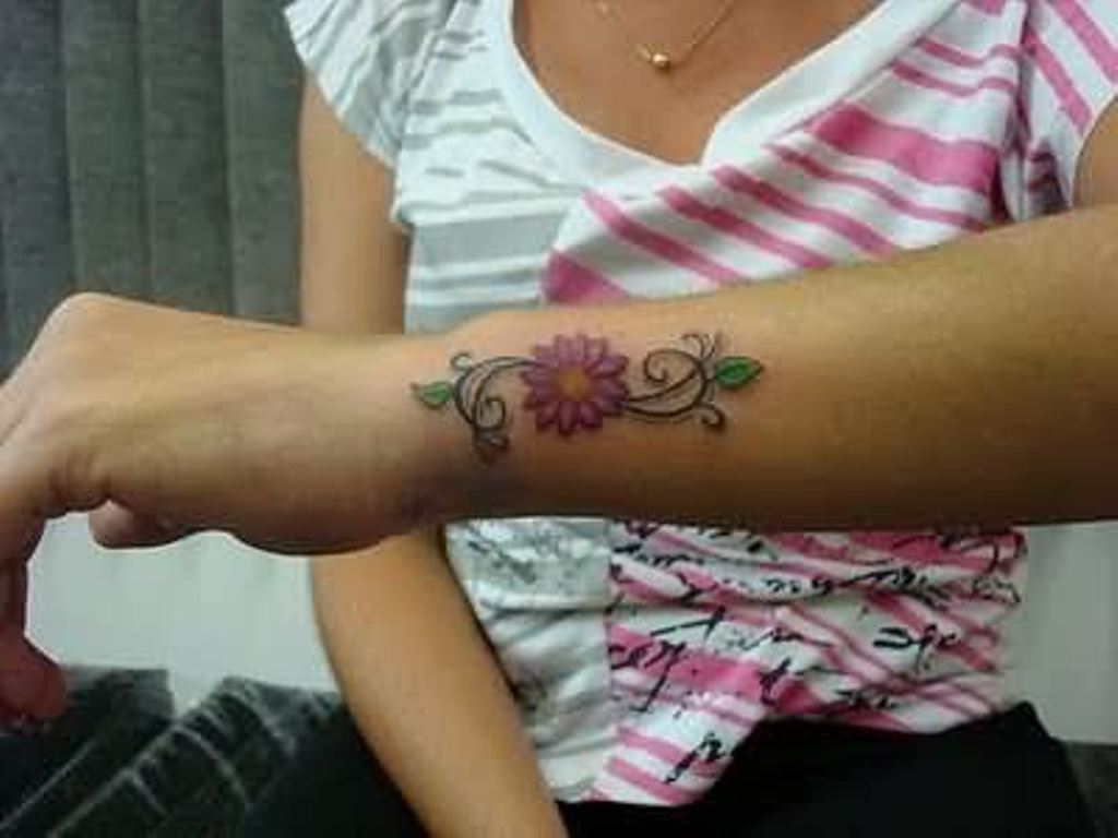 Girl With Small Daisy Flower Tattoo On Left Arm