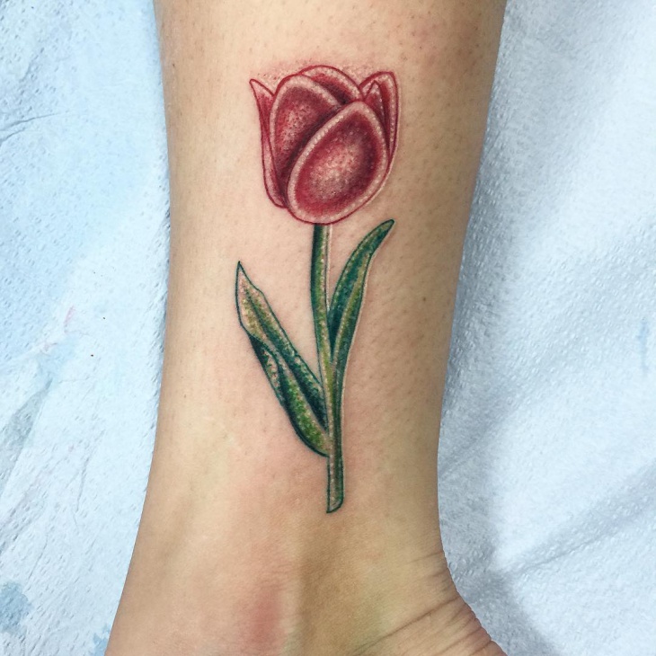 Green And Red Ink Tulip Flower Tattoo On Side Leg
