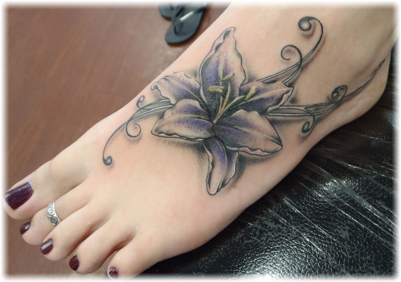 Grey And Purple Ink Lily Flower Tattoo On Girl Left Foot