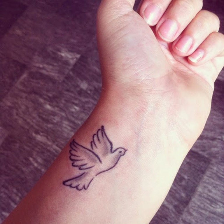 Grey Ink Flying Dove Tattoo On Wrist