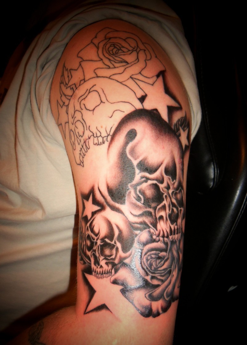 Grey Ink Skull And Stars Tattoo On Man Left Half Sleeve