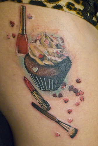 Lipstick And Makeup Brush With Cupcake Tattoo On Side Rib