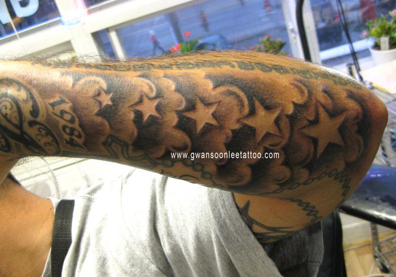 Man With Stars and Clouds Tattoo On Left Sleeve