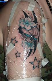 Nice Stars And Skull With Flower Tattoo On Girl Shoulder