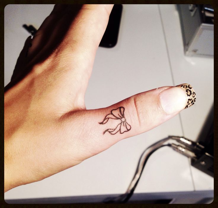 Outline Bow Tattoo On Thumb