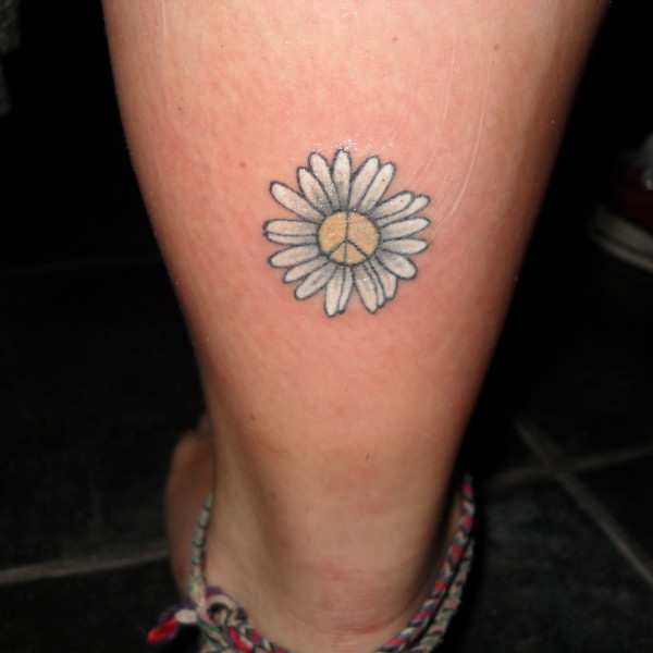 Peace Symbol In Small Daisy Tattoo On Back Leg