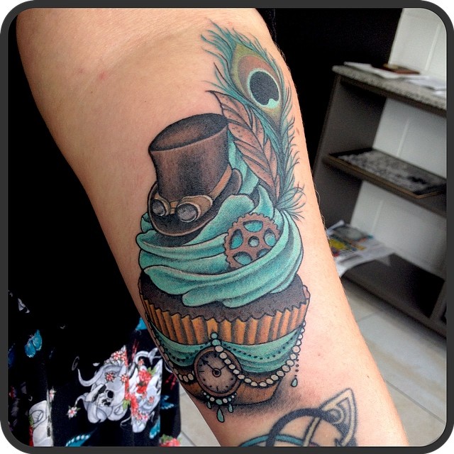 Peacock Feather And Cupcake Tattoo On Forearm