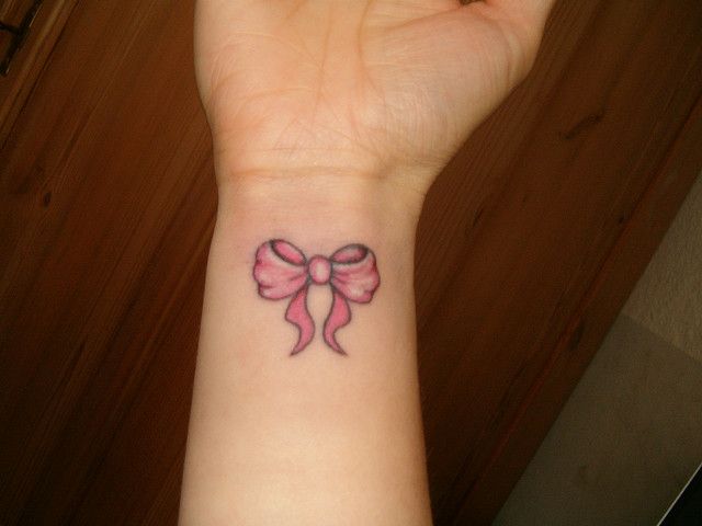 Pink Bow Tattoo On Girl Right Wrist