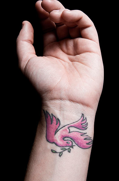 왼쪽 손목에 핑크 비행 비둘기 문신