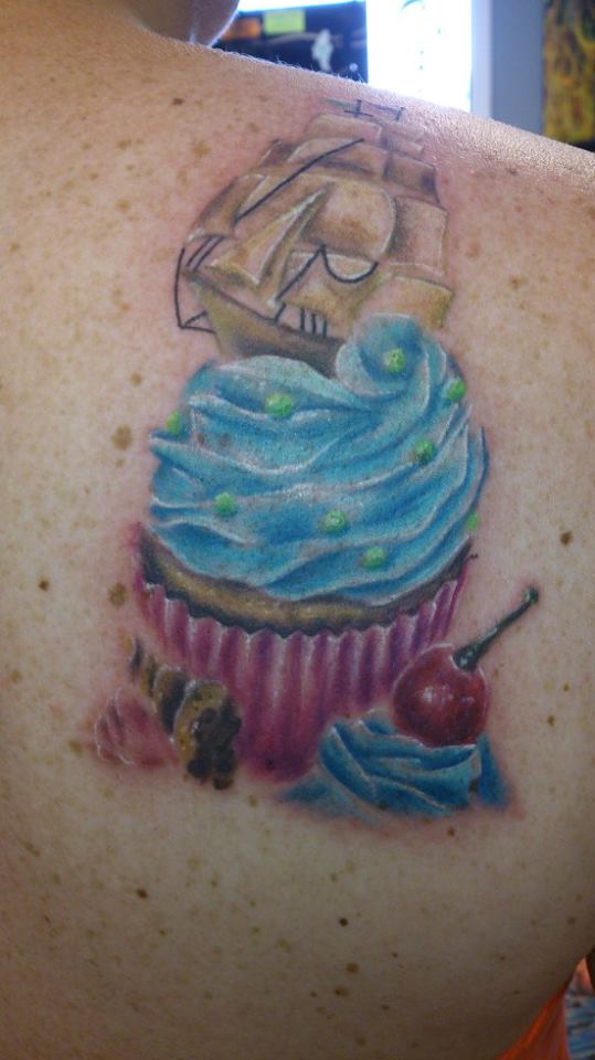 Ship And Realistic Cupcake Tattoo On Back Shoulder