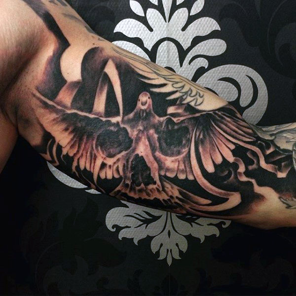 Skull In Flying Dove Tattoo On Inner Bicep