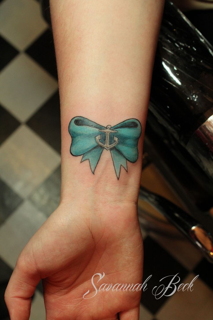 Small Anchor And Blue Bow Tattoo On Right Wrist
