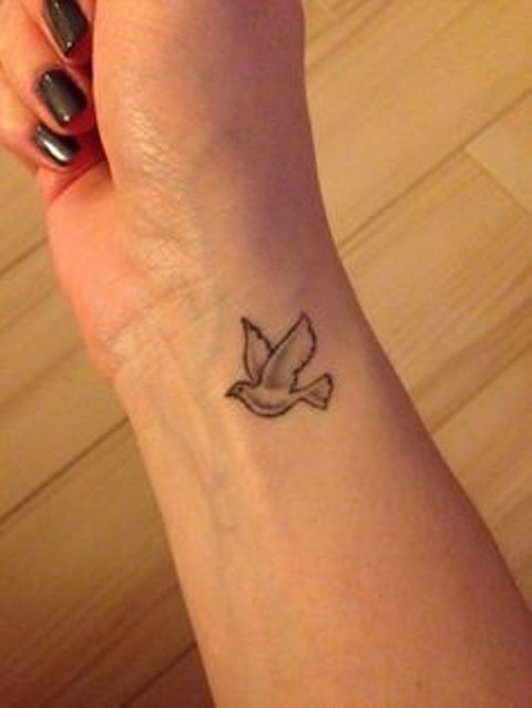 Kleine graue fliegende Taube Tattoo am rechten Handgelenk