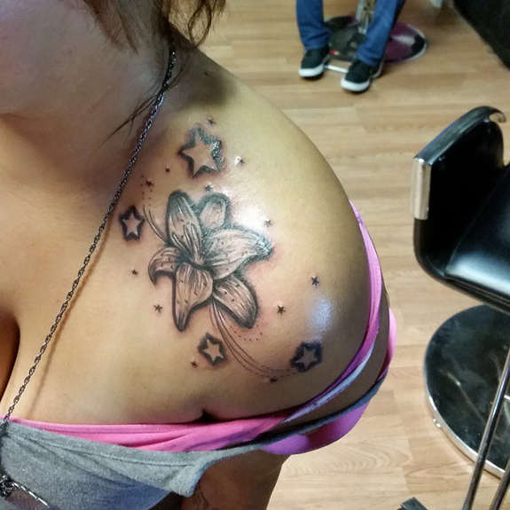 Stars And Lily Tattoo On Front Shoulder