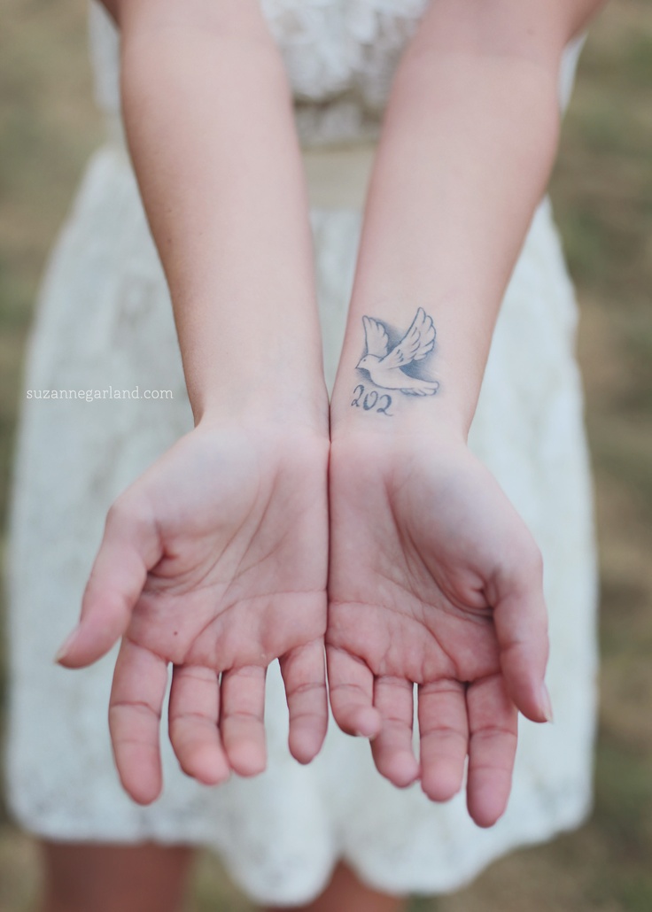 Weiße und graue fliegende Taube Tattoo am linken Handgelenk
