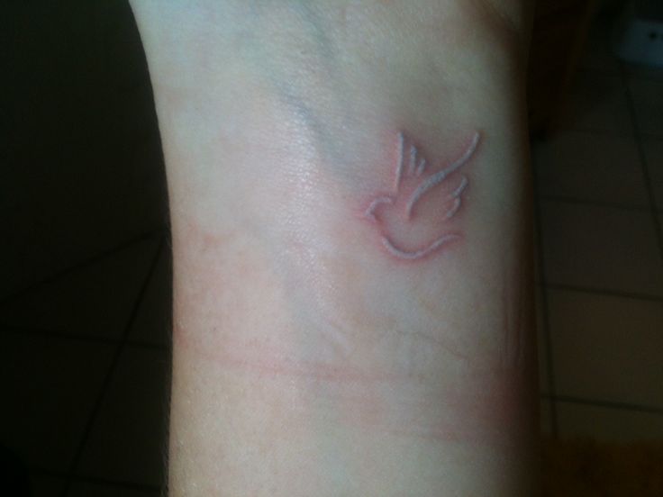 White Ink Flying Dove Tattoo On Wrist