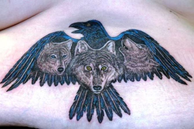 Wolf Heads In Raven Tattoo On Lower Back