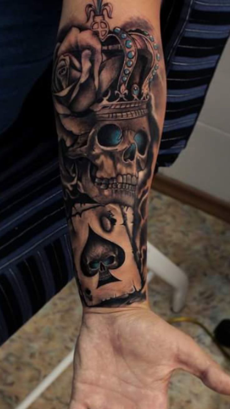 Crowned Skull And Spade Card Tattoo On Forearm