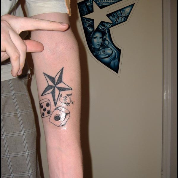 Nautical star And Dice Tattoo On Arm